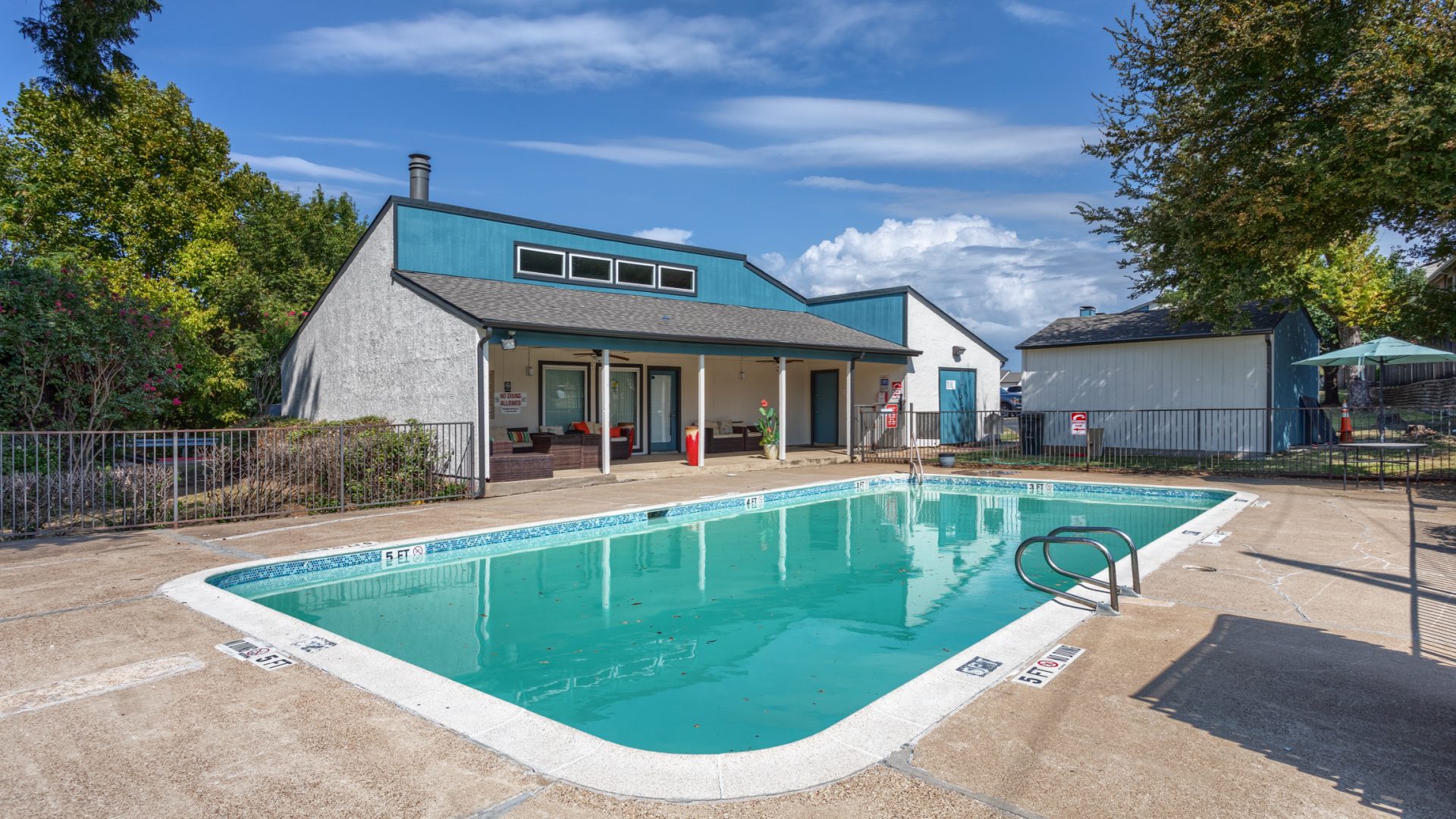 Picture of an apartment complex's clubhouse and pool area.